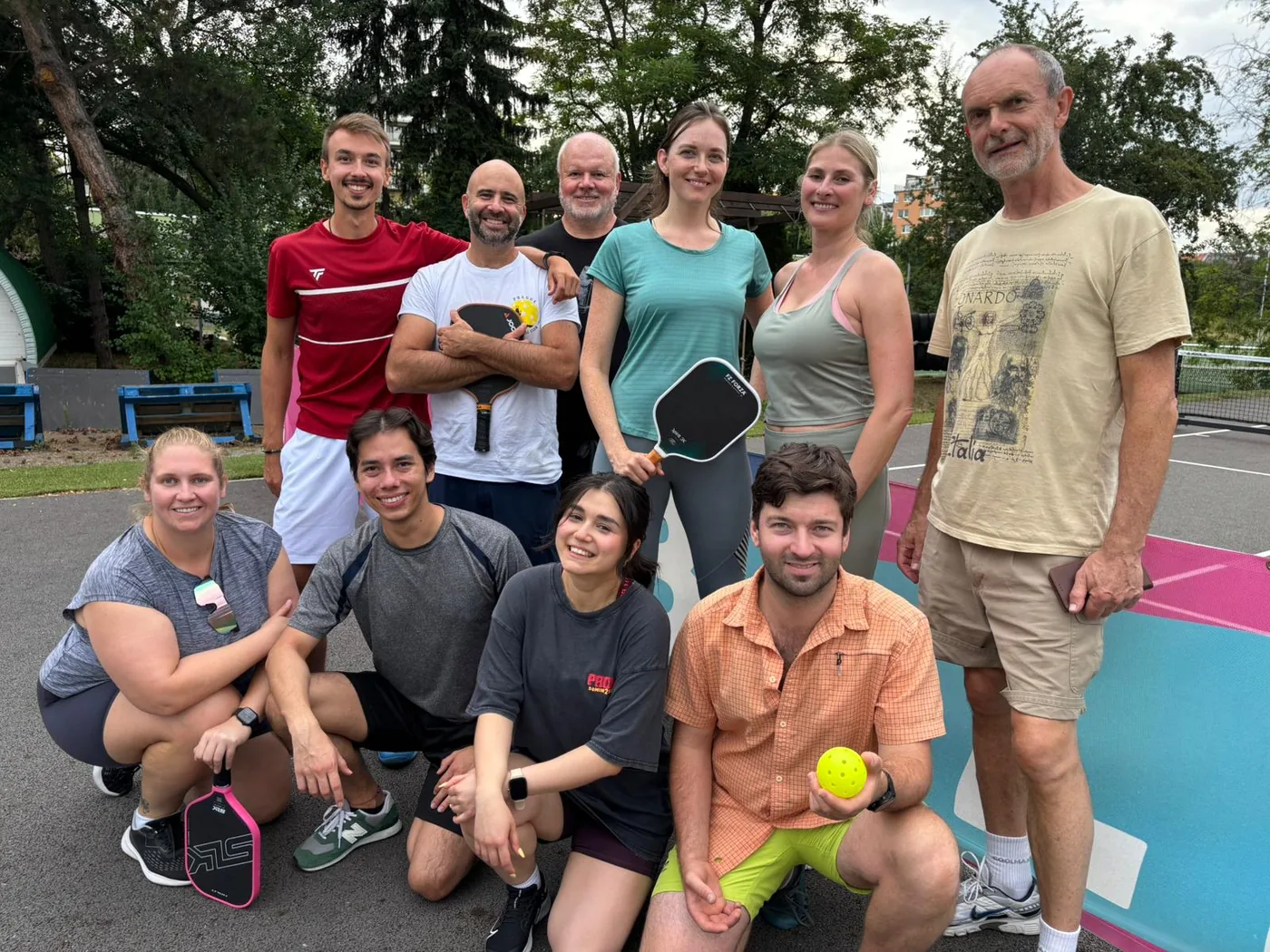 Skupina hráčů pickleballu s raketami po tréninku
