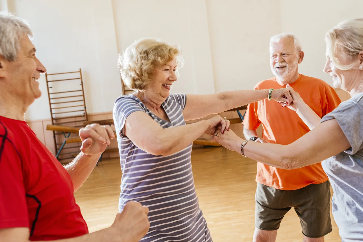 Skupina seniorů při společném cvičení v tělocvičně